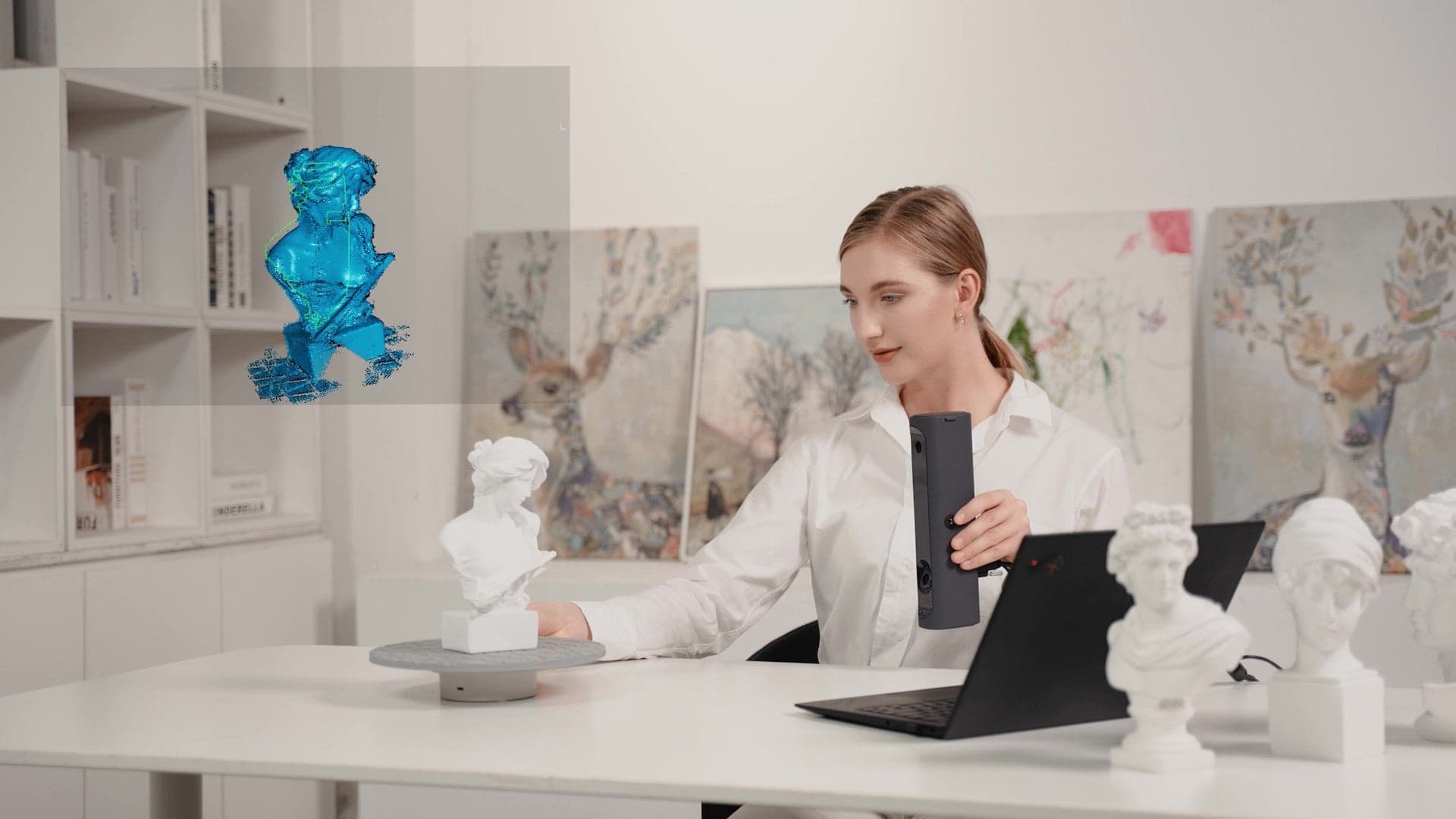 Woman scanning a bust in 0.25mm high resolution using MagicSwift Plus to capture detailed 3D models.